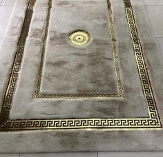 an area rug with gold trimmings and greek designs on the floor in a room