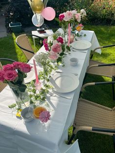 a long table with plates and flowers on it