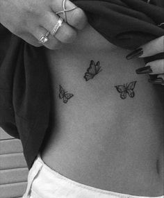 a woman's stomach with three butterflies on her side, and the bottom part of her belly