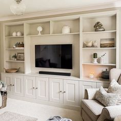 a living room filled with furniture and a flat screen tv on top of a wall