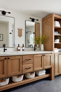 a bathroom with wooden cabinets and two sinks in the same room as well as mirrors on the wall