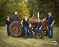 a family poses in front of an old tractor