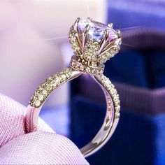 a close up view of a diamond ring on someone's finger