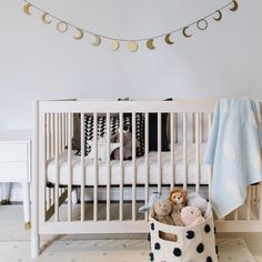 a white crib with teddy bears in it