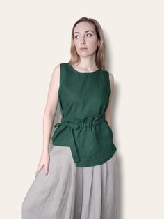 Tie waist linen blouse with front pocket. DETAILS: - 100% linen fabric (softened, 170-205g/m2).  - Sleeveless  - Pull over with tie side - Boat neck - CUSTOM ORDERS AVAILABLE. SIZING: - Please, refer to your body measurements (before purchasing) in our size chart as the picture of this listing.  🛑 SIZE CHART IS THE BODY MEASUREMENTS. - If you think that the standard sizes may not fit well, please write to me the measurements of your body, and you will get a garment made according to your person Green Sleeveless Linen Top, Green Sleeveless Tops With Pockets, Sleeveless Blouse With Pockets For Summer, Green Linen Tops With Pockets, Linen Sleeveless Blouse For Work, Sleeveless Linen Top For Work, Green Linen Blouse For Workwear, Linen Tank Top, Linen Tank