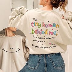 Dear Tiny Human Behind Me Sweatshirt, Teacher Sweatshirt, Inspirational Teacher Gift, Teacher Appreciation, New Teacher Shirt, Cute Teacher Thank you so much for taking the time to browse my shop. Please feel free to reach out if you have any questions before or after purchasing.  💖 🎨Warning: On products with a print chart in the listing, metallic print colors are printed as matte.✌✨ We design and cut each graphic out with a soft touch, use matte vinyl and a heat press. The result will last fo Meaningful Text Print Crew Neck Tops, Inspirational Crew Neck Top With Funny Text, Inspirational Crew Neck Tops With Letter Print, Meaningful Slogan Cotton Tops, White Long Sleeve Tops With Funny Text, Inspirational Cotton Crew Neck Sweatshirt, Funny Text Long Sleeve Cotton Sweatshirt, Long Sleeve Cotton Sweatshirt With Funny Text, White Long Sleeve Sweatshirt With Funny Text