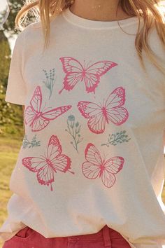 Garment-washed graphic t-shirt. Vintage-style graphic print with butterfly and flower graphics. Round neckline. Short sleeves. Relaxed fit. 100% Cotton. Imported top designed and printed in LA. Model wears size S. Butterfly Graphic Tee, Flower Graphics, Butterfly And Flower, Baby Graphic Tees, Butterfly Graphic, Graphic Tops, Vintage Canvas, Butterfly Garden, Iron Decor