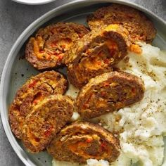 a bowl filled with mashed potatoes and meat patties next to a cup of sauce