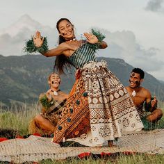 a group of people sitting on top of a grass covered field next to each other