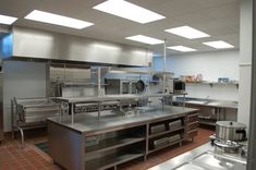 a commercial kitchen with stainless steel appliances and tile flooring is pictured in this image