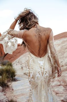 the back of a woman's dress with tattoos on it