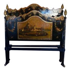 an antique painted bed frame with gold leaf accents and a painting on the headboard