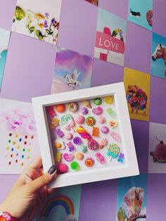 a person holding up a small white box with buttons in it on a purple background