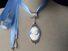 Blue Cameo Choker!This beautiful “Wedgwood Blue” cameo has been set in an antique silver pendant and attached to a blue satin ribbon....I have added teardrop pearls to the end of each tie...The perfect Mother’s Day gift for all those amazing and devoted Mom’s!Ribbon is available in light Wedgwood or dark Wedgwood Blue....please choose from the menu.....Please select if you would like this item gift wrapped.....I will also include a card with your personal message....Thank you for taking time to Vintage Cameo Jewelry For Wedding, Blue Cameo Necklace For Wedding, Blue Cameo Jewelry For Wedding, Antique Cameo Necklace For Wedding, Cameo Pendant Necklace For Wedding, Cameo Choker, Victorian Cameo, Wedgwood Blue, Necklace Antique