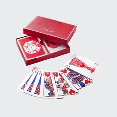 a red box with six playing cards in it and the card deck has four different designs