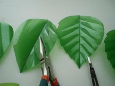 scissors and some paper leaves on a table