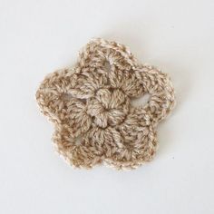 a crocheted flower is shown on a white surface with the center piece missing