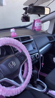 the steering wheel cover is pink and has hello kitty on it