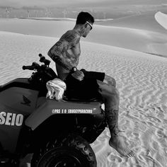 a man sitting on top of an atv in the desert