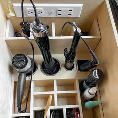 an open drawer with hair dryers and other items in it that are on display