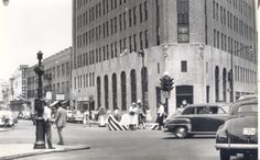 an old black and white photo of people on the street