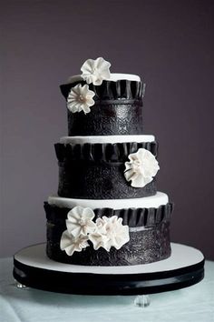 a black and white wedding cake with flowers on it