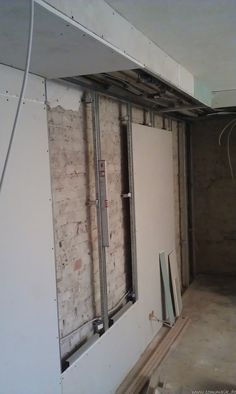 an unfinished room that is being renovated with exposed walls and metal bars on the ceiling