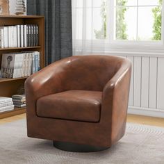 a brown leather chair sitting in front of a book shelf