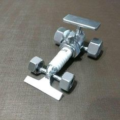 a small metal toy airplane sitting on top of a brown table next to a pair of dumbbells