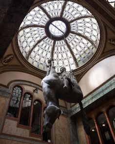 there is a horse statue in the middle of this room with a round window above it