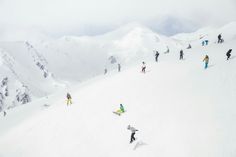 many people are snowboarding down a snowy mountain