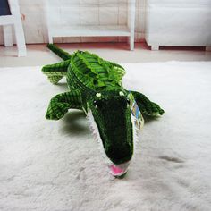 a stuffed alligator laying on top of a white rug