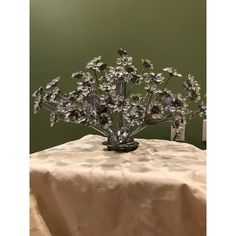 a silver flower arrangement sitting on top of a table