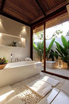 a bath room with a large tub and a plant in the corner on the floor