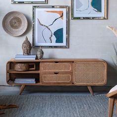 a living room with pictures on the wall and a sideboard in front of it