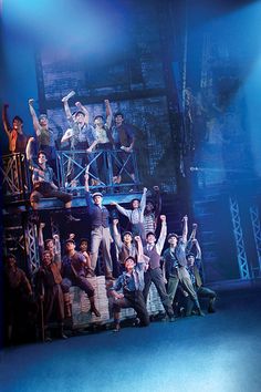 a group of people standing on top of a stage with their arms in the air