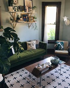 a living room filled with furniture and plants on top of a wooden table in front of a window