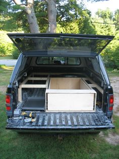 the back end of a pickup truck with an open trunk and two drawers in it