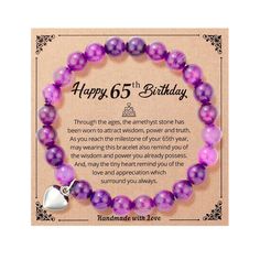 a purple and white bracelet with a heart charm on it's end that says happy 65th birthday