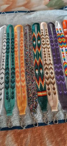 a row of bracelets sitting on top of a table next to each other in different colors