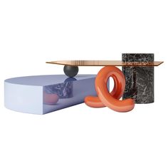 an unusual table with different shapes and materials on it, including a skateboard in the middle