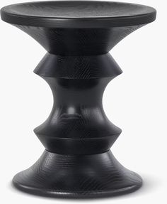 a black stool with three stacked sections on the top and one sitting on it's side