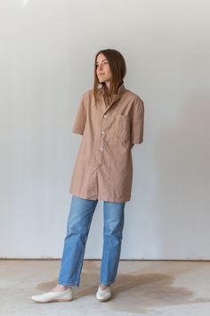 "This vintage workwear shirt has four white buttons, short sleeves and one left rounded pocket. Dusty Pink. Made in the 50s/60s. Garment Dyed in Los Angeles in 2020. Material: 100% Cotton 7 oz Condition: Good. Measurements-- -SMALL- Shoulders: 16.5\" | Chest: 19\" | Length: 28\" | Sleeve: 10.5\" -MEDIUM- Shoulders: 17\" | Chest: 21\" | Length: 30\" | Sleeve: 11\" -LARGE- Shoulders: 18\" | Chest: 23\" | Length: 30\" | Sleeve: 11\" -X-LARGE- Shoulders: 20\" | Chest: 25\" | Length: 30\" | Sleeve: 1 Beige Collared Short Sleeve Shirt With Pockets, Vintage Unstructured Tops For Everyday, Vintage Unstructured Top For Everyday, Relaxed Fit Short Sleeve Collared Shirt With Buttoned Pockets, Relaxed Fit Collared Short Sleeve Shirt With Buttoned Pockets, Vintage Loose Fit Top For Everyday, Vintage Unstructured Collared Tops, Unstructured Collared Vintage Tops, Collared Short Sleeve Shirt With Pockets For Daywear