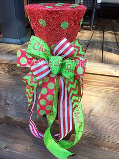 a red and green christmas tree topper on a porch