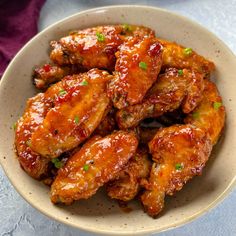 a bowl filled with chicken wings covered in sauce