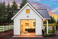 a small white house with an open garage door