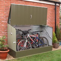 two bikes are parked in the back of a storage shed that is open to allow bicycles