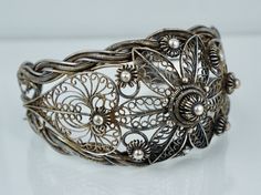 "A spectacular cuff. This Chinese Export cuff is crafted from 900/1000 silver and features an intricate spun wire filigree design. The cuff is in very good condition and is not missing any of the filigree, there it does have a noticeable ding. It is clearly hallmarked \"CHINA SILVER\", weighs 46.1 grams, and test positive for a minimum of 900 silver. The cuff measures approximately 6 inches end to end with a 1 1/2 inch opening and is 1 5/8 inches at the widest point. A fantastic example of Chine Ornate Adjustable Cuff Bracelet With Intricate Design, Adjustable Ornate Cuff Bracelet With Intricate Design, Antique Silver Cuff Bracelet With Intricate Design For Wedding, Antique Silver Wedding Cuff Bracelet With Intricate Design, Wedding Antique Silver Cuff Bracelet With Intricate Design, Victorian Cuff Bracelet With Intricate Design, Antique Wedding Cuff Bracelet With Intricate Design, Silver Filigree Bangle For Wedding, Victorian Cuff Bracelet With Intricate Design For Weddings