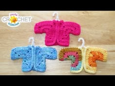 three crocheted sweaters hanging from hooks on a wooden surface with the words crochet written below them