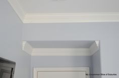 the corner of a room with a white door and some molding on the ceiling